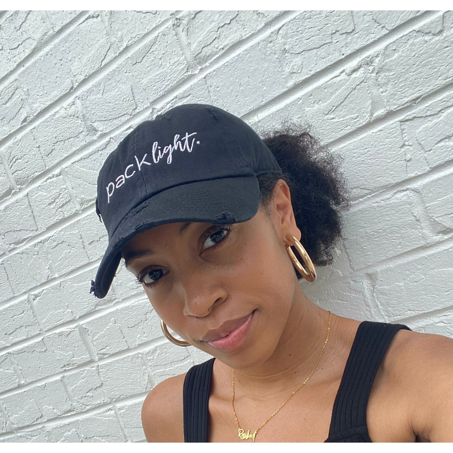 model wearing black Pack Light affirmation hat from Sol Rise Essentials