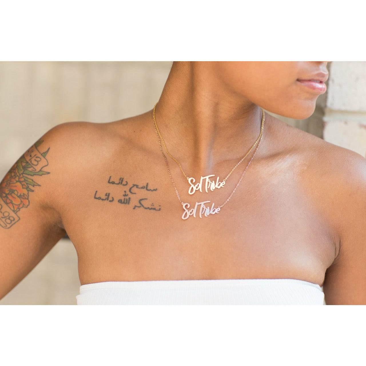 close up of woman wearing Sol Tribe affirmation necklace in gold and rose gold from Sol Rise Essentials
