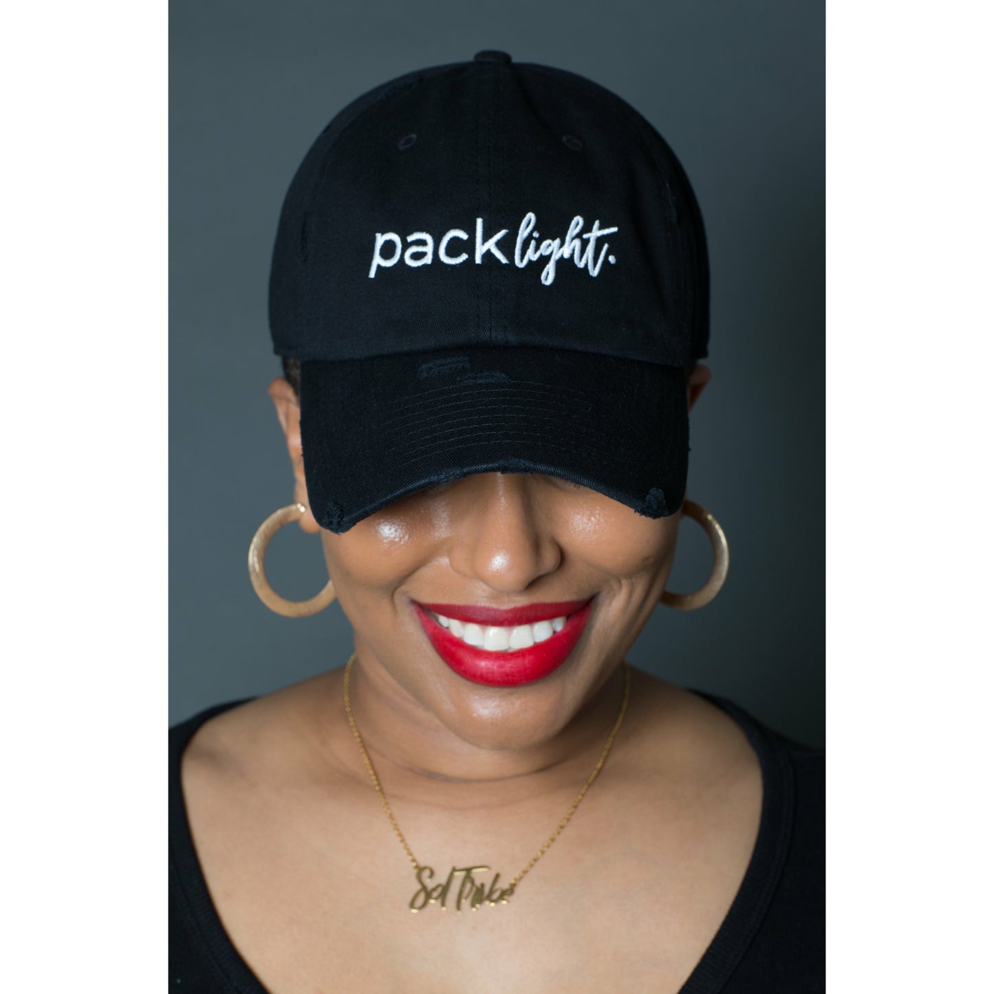 model wearing black Pack Light affirmation hat from Sol Rise Essentials
